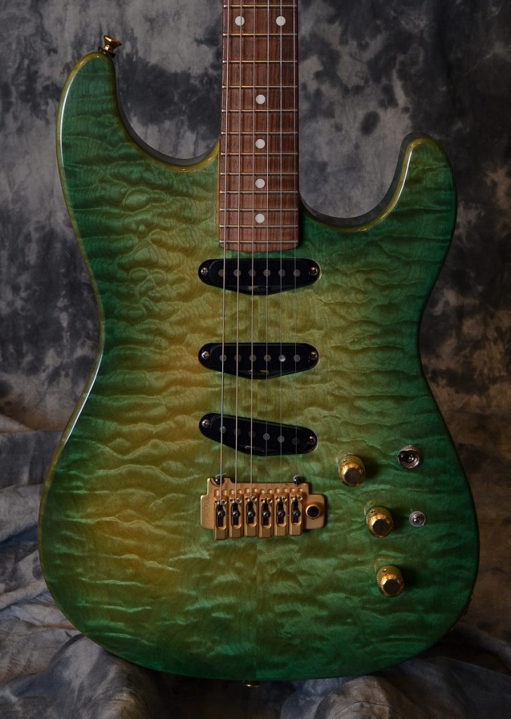 Now commonly know for his outstanding acoustic guitars here is a rare solid body strat style guitar from builder Michael Greenfield. It has a very unique look with its trans green finish on the maple cap.