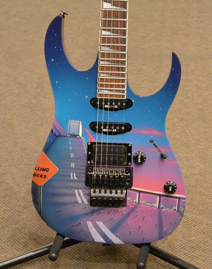 This US made custom Ibanez guitar features a unique road scene graphic on a blue finish, the Wizard neck and original Edge tremolo. Comes with original hardshell case.