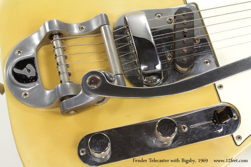 The Telecaster is not only the first succesful (wildly!) solidbody electric guitar, but it's also been in uninterrupted production the longest.   

There have been some variations over the years, and this 1969 Fender Telecaster with Bigsby is a prime example.  The Bigsby unit itself is the oldest successful vibrato unit made, and as we can see here it's been available in a branded form to manufacturers.   This unit has the 'F' logo on the body casting.  To go with this, the body does not have the string ferrules on the back; there is a custom pickup plate and a Jazzmaster-style bridge is used.   This one even has the original bridge cover!