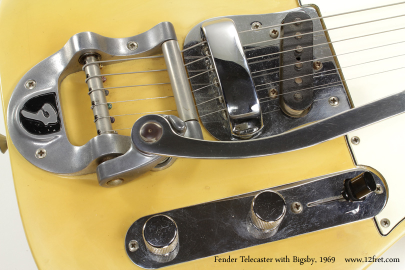 The Telecaster is not only the first succesful (wildly!) solidbody electric guitar, but it's also been in uninterrupted production the longest.   

There have been some variations over the years, and this 1969 Fender Telecaster with Bigsby is a prime example.  The Bigsby unit itself is the oldest successful vibrato unit made, and as we can see here it's been available in a branded form to manufacturers.   This unit has the 'F' logo on the body casting.  To go with this, the body does not have the string ferrules on the back; there is a custom pickup plate and a Jazzmaster-style bridge is used.   This one even has the original bridge cover!