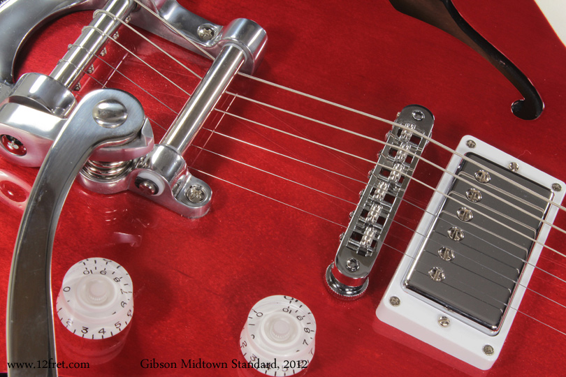 Here is something new - a Gibson Midtown Standard  with Bigsby.    Always on the search for new ideas, in 2011 Gibson introduced the Midtown as a blend of classic designs and new features and technologies. 

The Midtown is based on the visuals of the ES-3xx series guitars, and is thinline but isn't arched, it's a chambered, flat top guitar.  The top is solid maple (rather than laminate as on the ES-3xx series) and the back is chambered mahogany.