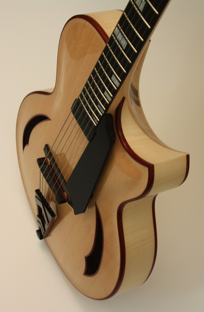 Jeff Letain builds innovative archtops in Sooke, British Columbia.  We saw the Eraser at the Montreal guitar show and it had to come here!

A unique feature of this guitar is the interior concealed neck block offering unfettered access to all of the upper frets.  This innovation offers maximum playability and balances the instrument beautifully.  Both the pin and the tail piece have a beautiful chevron design incorporated into them.