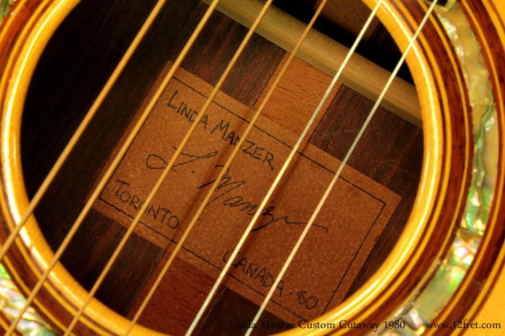 This is a lovely guitar by Linda Manzer, built in 1980 in Toronto. It's been played - as it should be! - and is in good shape. It speaks very well with clear, articulated trebles and a full yet not overwhelming bass. The inlay is very well executed, and all around this is a wonderful instrument.